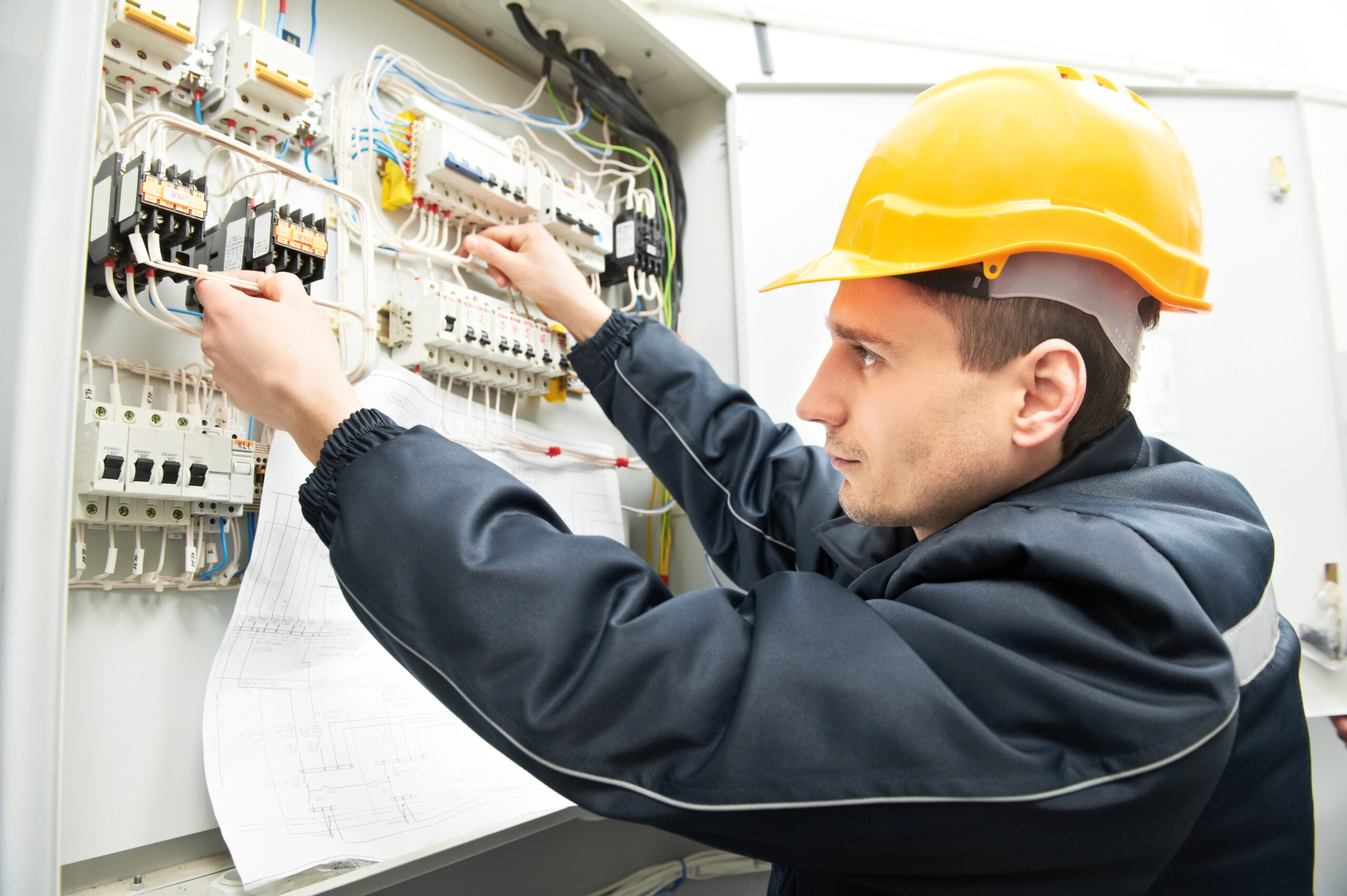 Electrician with drawing at power line box