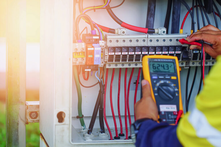 Workers use Multimeter to measure the voltage of electrical wires produced from solar energy for confirm to systems working normal.