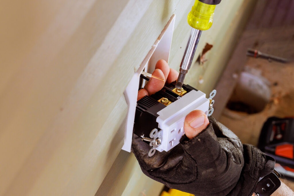 During installation of new outlet, electrical wires are connected to crucial stage in home wiring process.