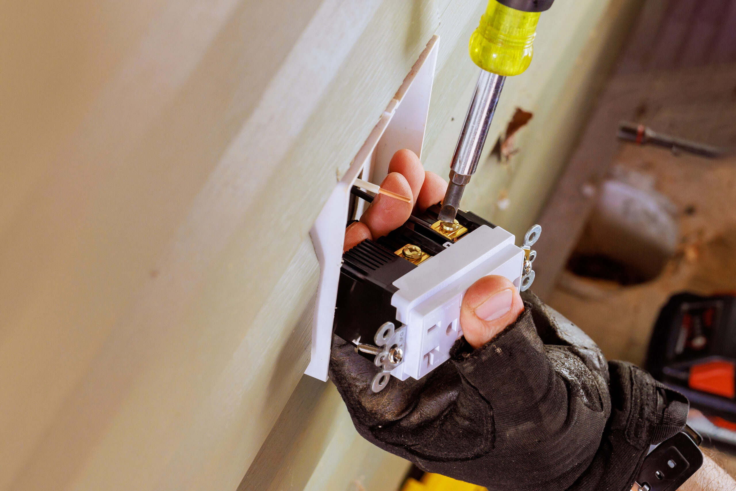 During installation of new outlet, electrical wires are connected to crucial stage in home wiring process.